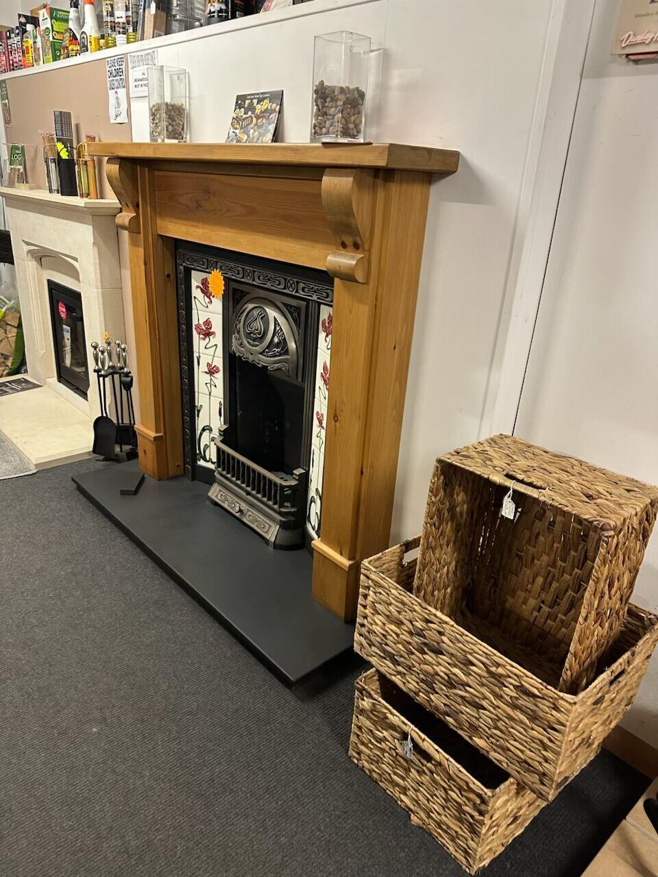 Pine mantel tiled fireplace with wicker log baskets alongside